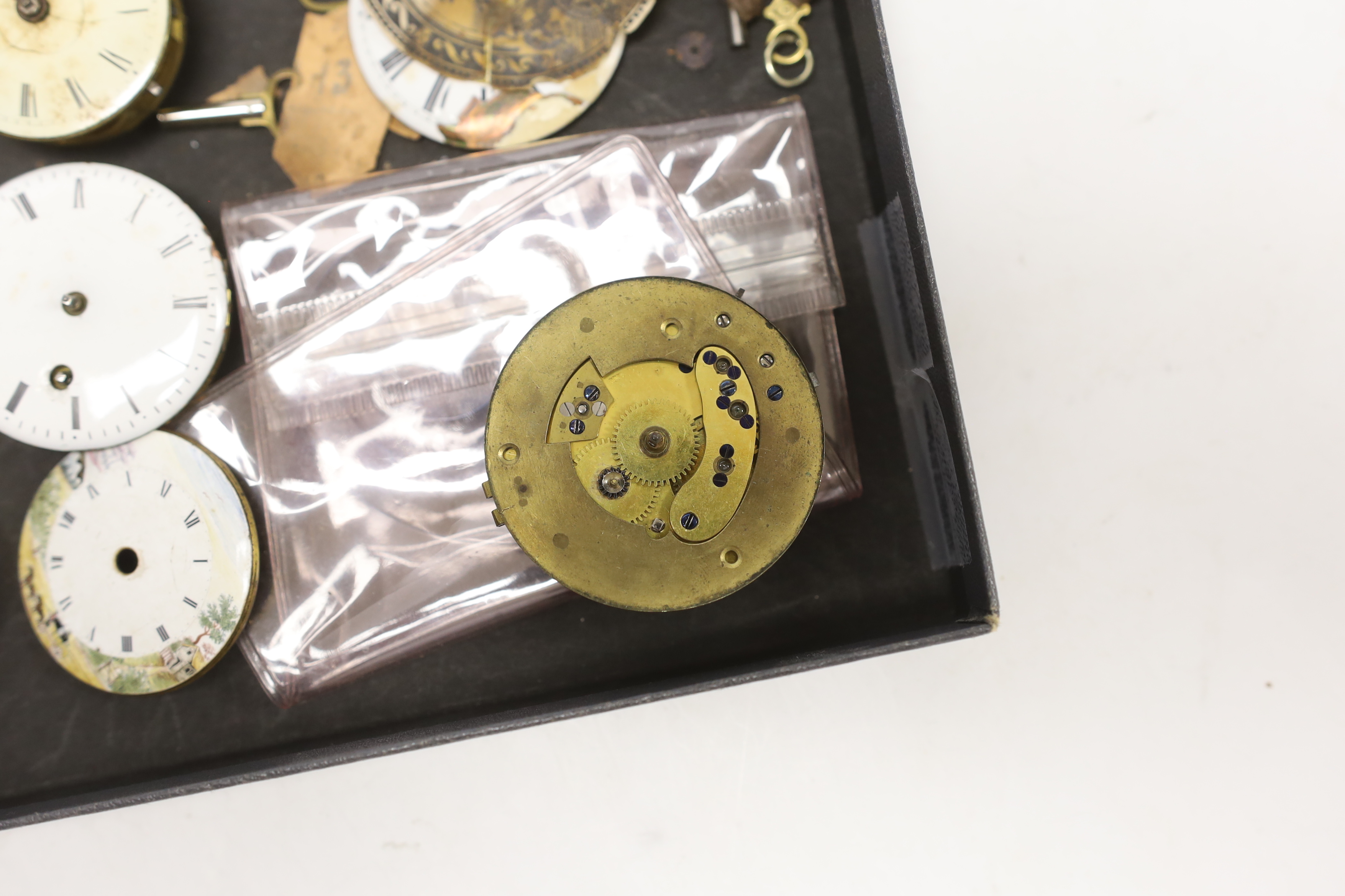 A small quantity of pocket watch accessories, including movements, dials and watch keys.